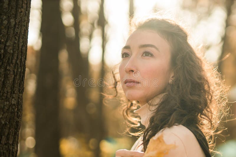 Ritratto di donna che cammina nel parco autunnale felice umore e moda stile moda e capelli marroni lunghi e ricci spazio. caduta immagini stock