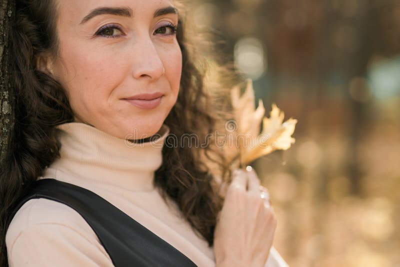 Ritratto di donna che cammina nel parco autunnale felice umore e moda stile moda e capelli marroni lunghi e ricci spazio. caduta fotografie stock