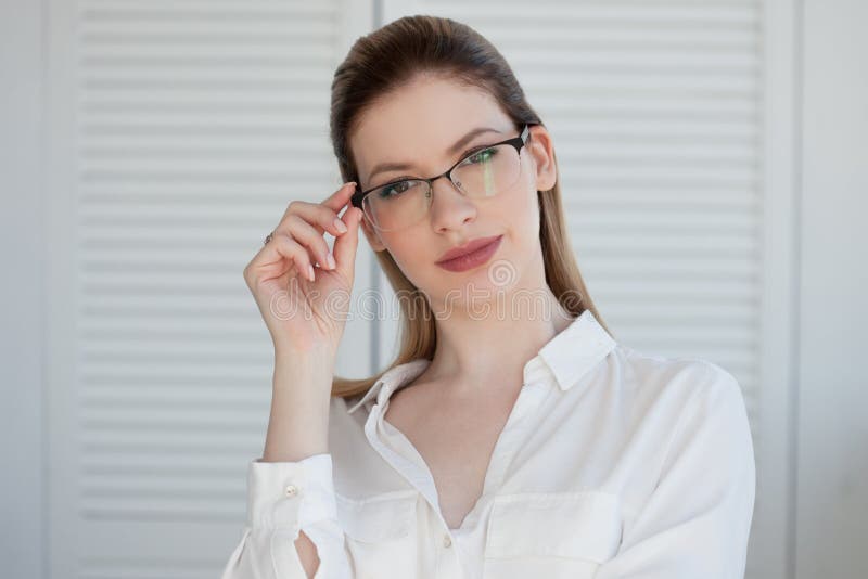 Ritratto di giovane donna alla moda di affari in camicia bianca e vetri fotografie stock libere da diritti Ritratto di giovane donna alla moda di affari in camicia bianca e vetri fotografie stock libere da diritti