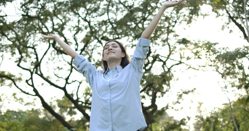 Ritratto di giovane donna asiatica attraente con emozione felice in un parco di estate