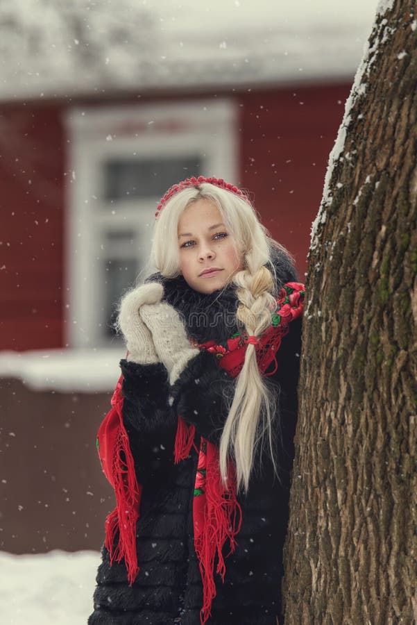 Ritratto di giovane donna caucasica nello stile russo su un forte gelo in un giorno nevoso di inverno Ragazza di modello russa fotografia stock Ritratto di giovane donna caucasica nello stile russo su un forte gelo in un giorno nevoso di inverno Ragazza di modello russa fotografia stock