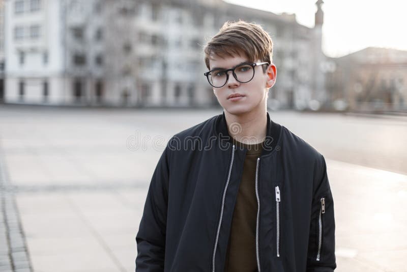 Ritratto di giovane maschio attraente dei pantaloni a vita bassa in vetri con un'acconciatura alla moda in tuta sportiva alla mod fotografia stock libera da diritti Ritratto di giovane maschio attraente dei pantaloni a vita bassa in vetri con un'acconciatura alla moda in tuta sportiva alla mod fotografia stock libera da diritti