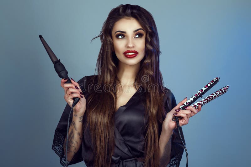 Ritratto di giovane modello sorridente con i denti perfetti e la bacchetta della tenuta di seta del peignoir dei capelli lunghi e fotografia stock libera da diritti Ritratto di giovane modello sorridente con i denti perfetti e la bacchetta della tenuta di seta del peignoir dei capelli lunghi e fotografia stock libera da diritti