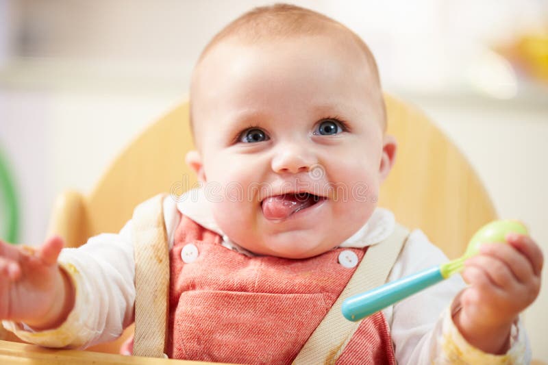 Ritratto di giovane neonato felice nel seggiolone immagini stock Ritratto di giovane neonato felice nel seggiolone immagini stock