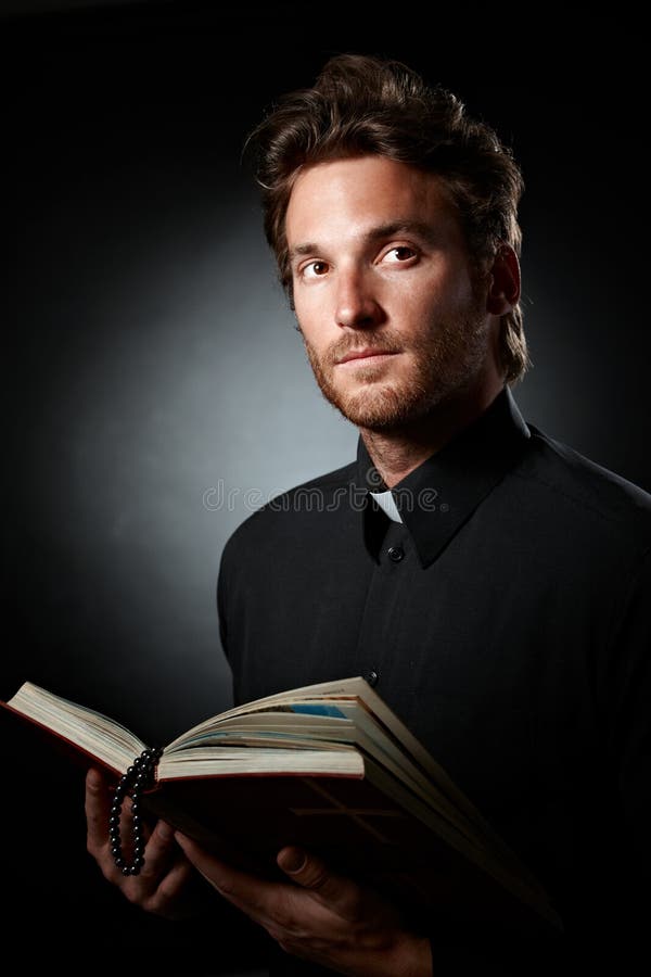 Ritratto di giovane sacerdote con la bibbia. fotografie stock libere da diritti Ritratto di giovane sacerdote con la bibbia. fotografie stock libere da diritti
