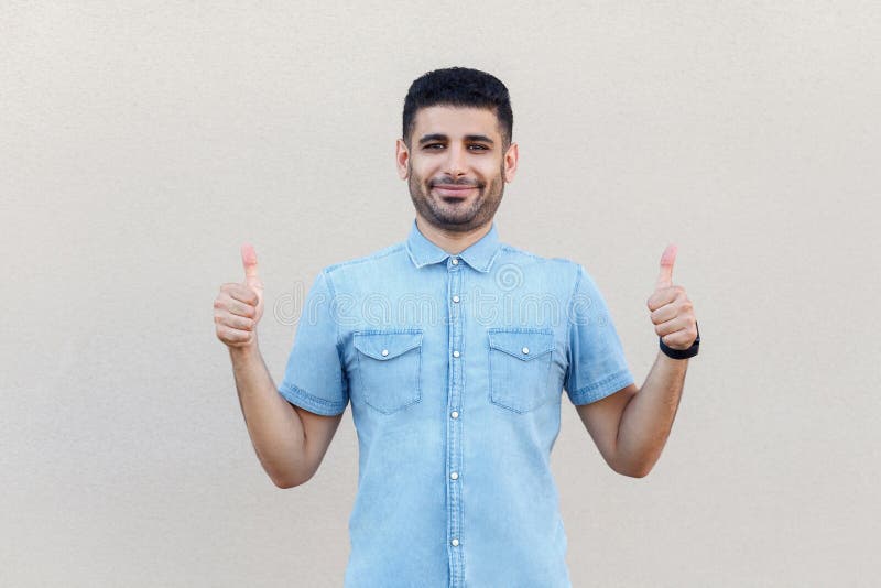 Ritratto di giovane uomo d'affari barbuto bello felice soddisfatto nella condizione, nel sorridere, nei pollici su come il gesto fotografia stock Ritratto di giovane uomo d'affari barbuto bello felice soddisfatto nella condizione, nel sorridere, nei pollici su come il gesto fotografia stock