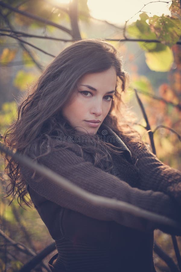 Ritratto di inverno della giovane donna in foresta al tramonto fotografie stock libere da diritti Ritratto di inverno della giovane donna in foresta al tramonto fotografie stock libere da diritti