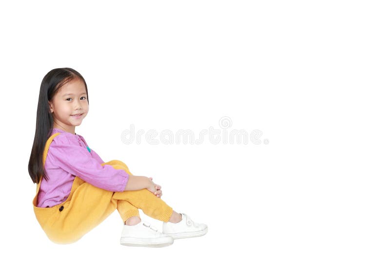 Ritratto di piccola ragazza asiatica felice del bambino nella seduta rosa-gialla rosa-gialla dei denim isolata sul fondo bianco c immagini stock libere da diritti Ritratto di piccola ragazza asiatica felice del bambino nella seduta rosa-gialla rosa-gialla dei denim isolata sul fondo bianco c immagini stock libere da diritti