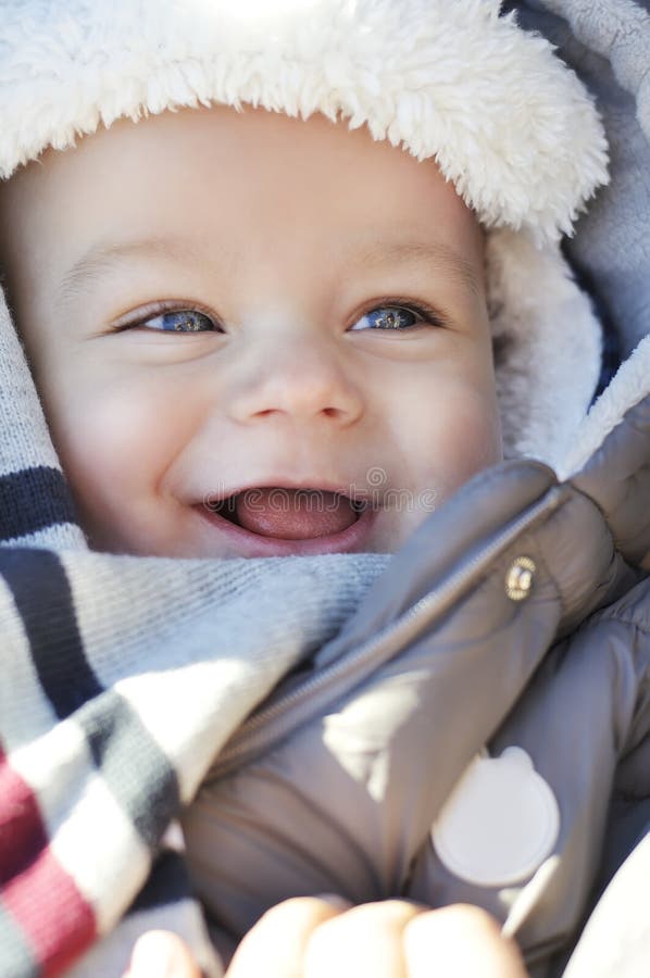 Ritratto di piccolo neonato sveglio sorridente che porta il cappello caldo di inverno fotografia stock libera da diritti Ritratto di piccolo neonato sveglio sorridente che porta il cappello caldo di inverno fotografia stock libera da diritti