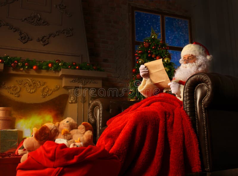 Ritratto di Santa Claus felice che si siede alla sua stanza a casa vicino all'albero di Natale e che legge la lettera o la lista immagine stock libera da diritti Ritratto di Santa Claus felice che si siede alla sua stanza a casa vicino all'albero di Natale e che legge la lettera o la lista immagine stock libera da diritti