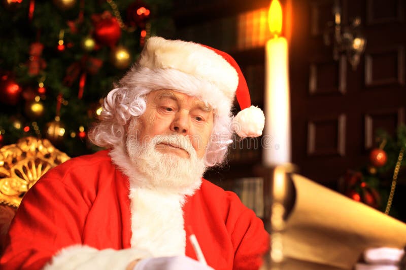 Ritratto di Santa Claus felice che si siede alla sua stanza a casa vicino all'albero di Natale e che legge la lettera o la lista immagini stock libere da diritti Ritratto di Santa Claus felice che si siede alla sua stanza a casa vicino all'albero di Natale e che legge la lettera o la lista immagini stock libere da diritti