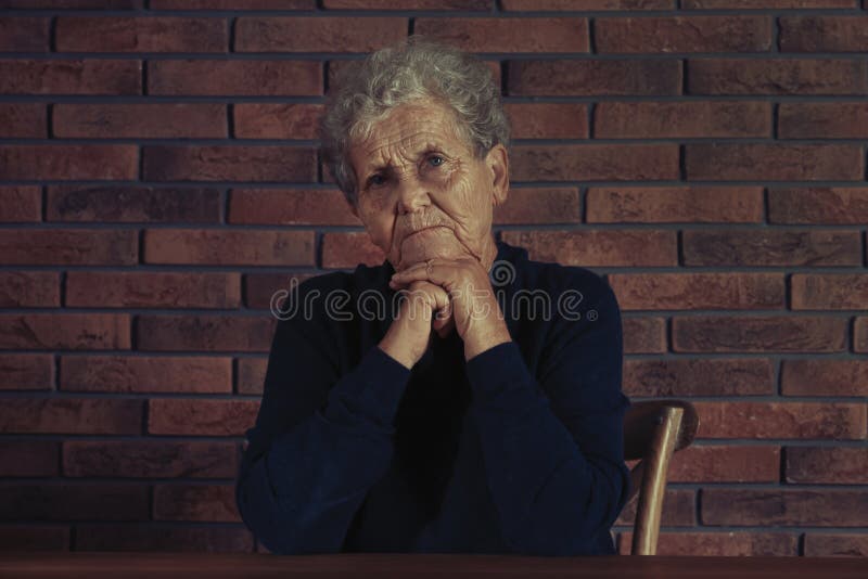 Ritratto di seduta anziana difficile della donna fotografia stock Ritratto di seduta anziana difficile della donna fotografia stock