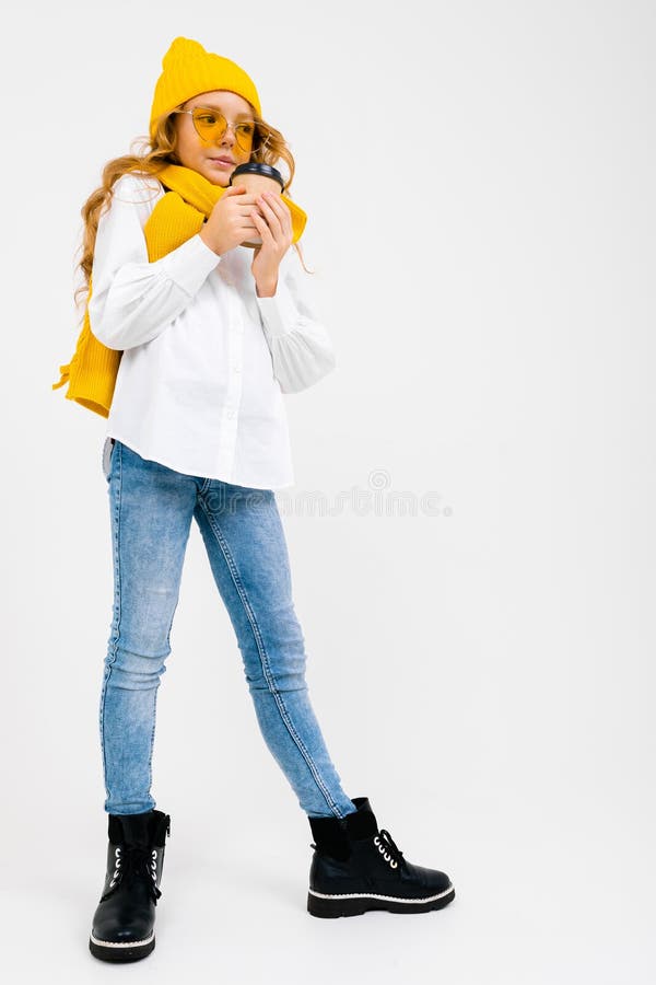 Ritratto di un'affascinante ragazza sorridente ed elegante con cappello invernale con una tazza di carta su sfondo bianco fotografie stock Ritratto di un'affascinante ragazza sorridente ed elegante con cappello invernale con una tazza di carta su sfondo bianco fotografie stock