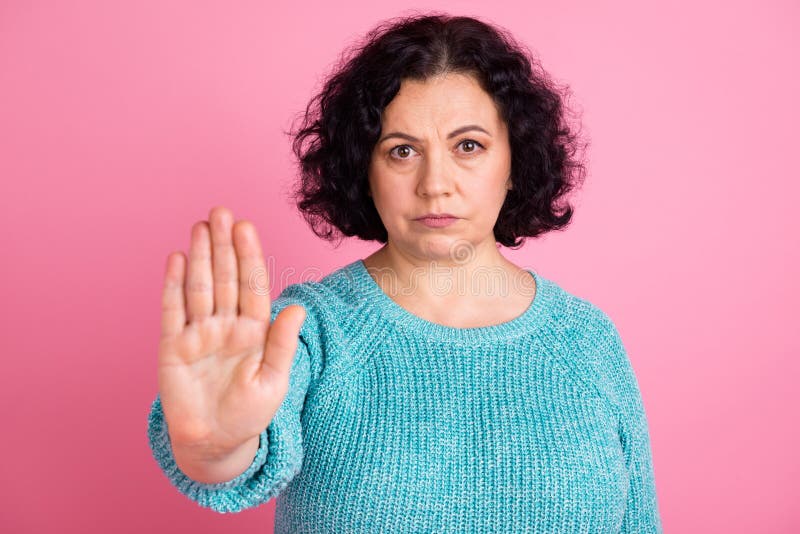 Ritratto di un'attraente autorità di una vecchia donna che mostra il cartello di stop delle palme isolato sullo sfondo di colore p fotografia stock libera da diritti