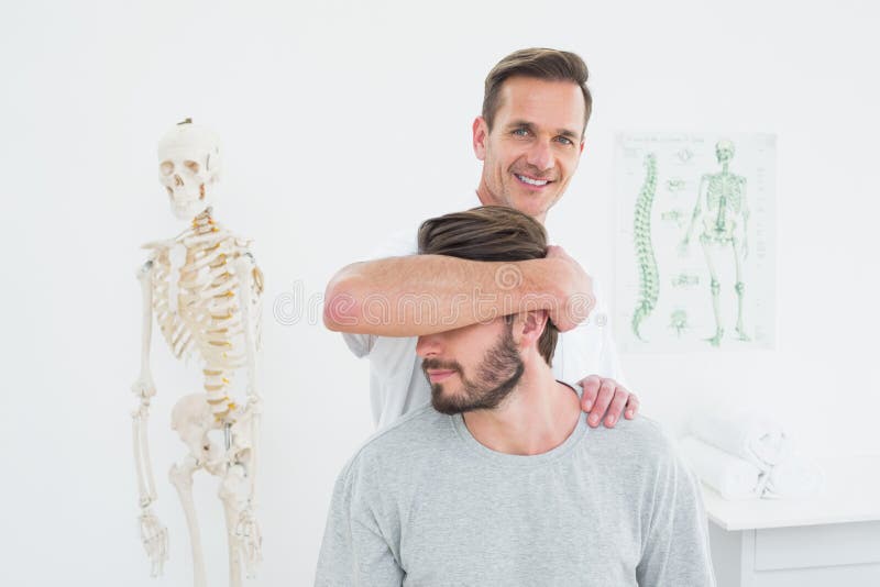 Ritratto di un chiropratico maschio che fa adeguamento del collo fotografie stock libere da diritti