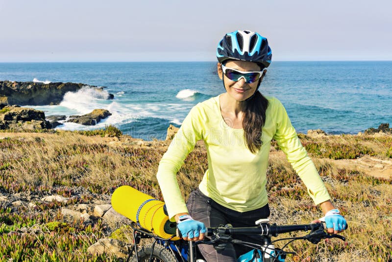 Ritratto di un ciclista turistico felice sui precedenti dell'oceano, fotografia stock Ritratto di un ciclista turistico felice sui precedenti dell'oceano, fotografia stock