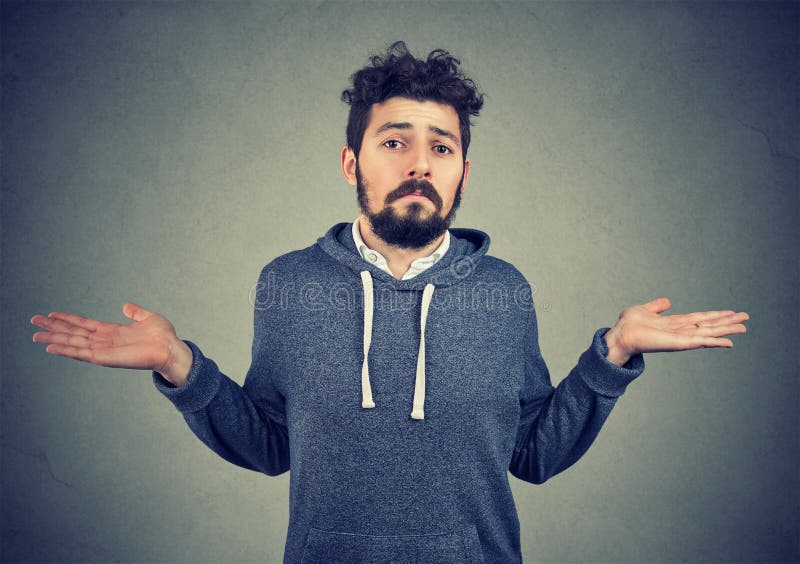 Ignorance and arrogance. Portrait of a young man shrugging shoulders feeling clueless isolated on gray background. Whatever attitude reaction. Ignorance and arrogance. Portrait of a young man shrugging shoulders feeling clueless isolated on gray background. Whatever attitude reaction