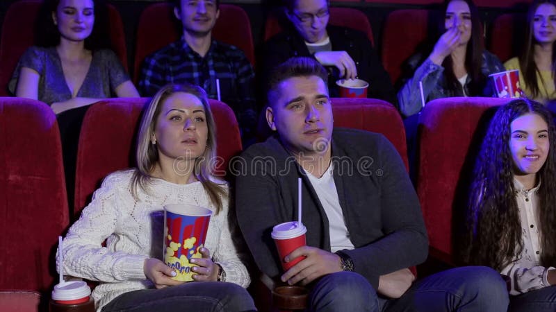 Ritratto di un gruppo di giovani in un cinema con popcorn e cola