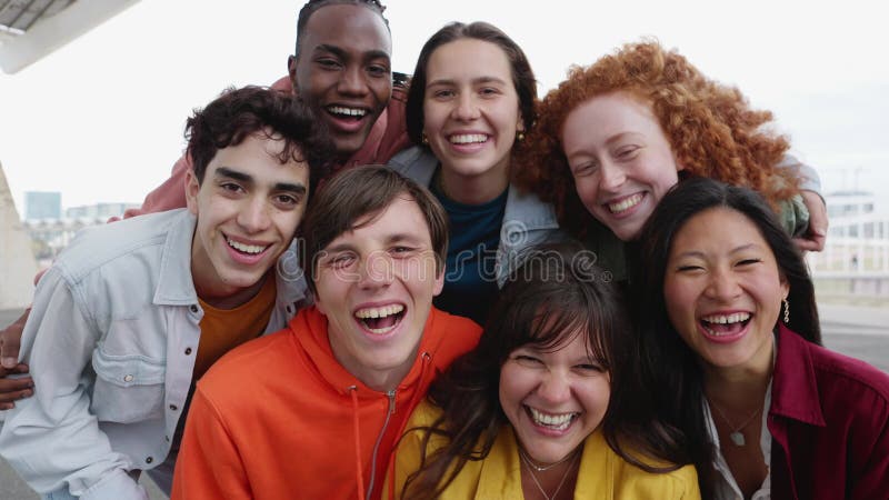 Ritratto di un gruppo multirazziale di giovani amici sorridenti davanti alla telecamera