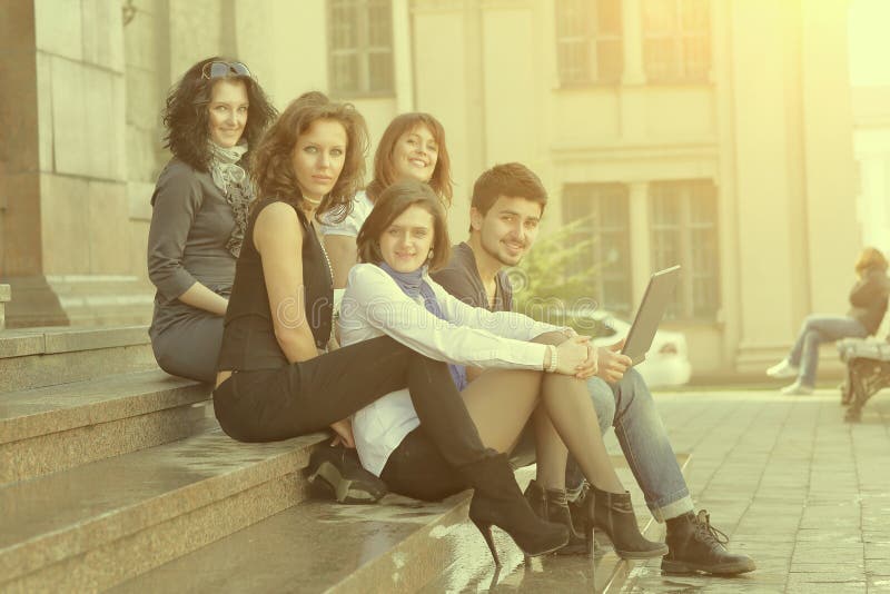 Ritratto di un gruppo di studenti che si siedono davanti all'università fotografia stock libera da diritti Ritratto di un gruppo di studenti che si siedono davanti all'università fotografia stock libera da diritti