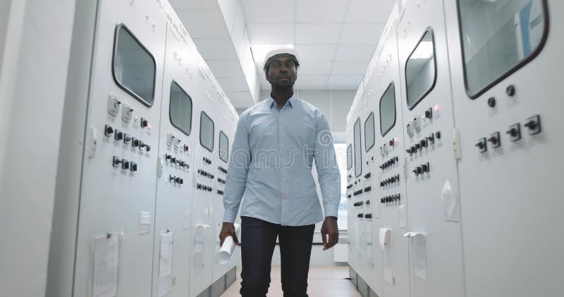 Ritratto di un ingegnere in cappello fisso al progetto di produzione per mano. stock footage
