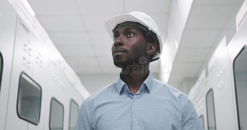 Ritratto di un ingegnere in cappello fisso al progetto di produzione per mano. stock footage