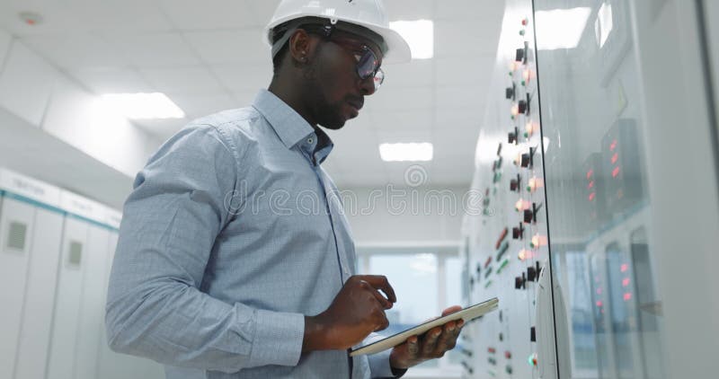 Ritratto di un ingegnere con un cappello fisso che tiene in mano una compressa. stock footage