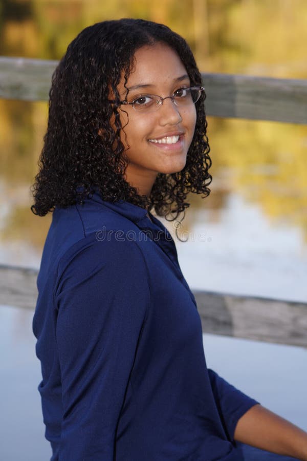 A portrait of a teenage girl smiling by the pond. A portrait of a teenage girl smiling by the pond