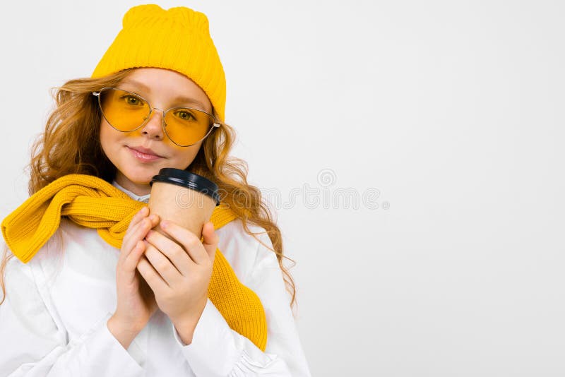 Ritratto di una affascinante ragazza sorridente con cappello invernale con una tazza di carta su sfondo bianco fotografia stock Ritratto di una affascinante ragazza sorridente con cappello invernale con una tazza di carta su sfondo bianco fotografia stock