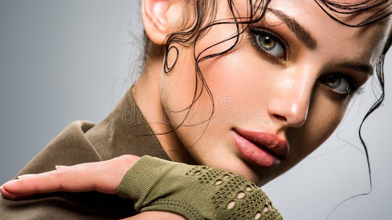 Closeup portrait of a beautiful young fashion woman with glamour makeup. Portrait of an attractive woman in green clothes. Closeup portrait of a beautiful young fashion woman with glamour makeup. Portrait of an attractive woman in green clothes