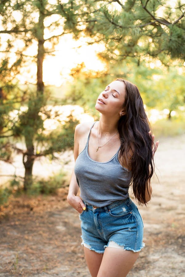 Ritratto di una bella giovane donna in piedi vicino alle foglie all'aperto fotografia stock Ritratto di una bella giovane donna in piedi vicino alle foglie all'aperto fotografia stock