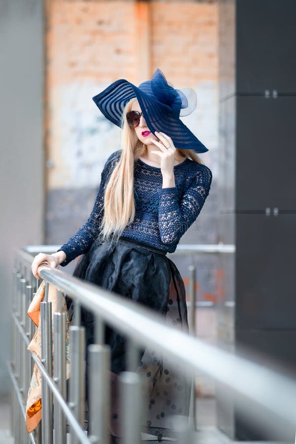 Ritratto di una bella ragazza bionda con cappello e occhiali da sole all'aperto immagini stock Ritratto di una bella ragazza bionda con cappello e occhiali da sole all'aperto immagini stock