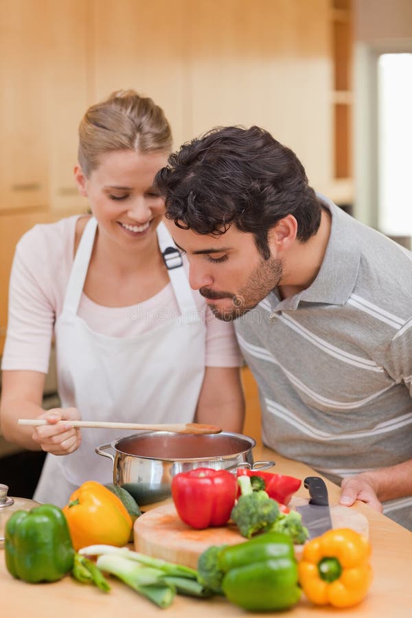 Ritratto di una coppia felice che prepara una salsa fotografia stock libera da diritti Ritratto di una coppia felice che prepara una salsa fotografia stock libera da diritti