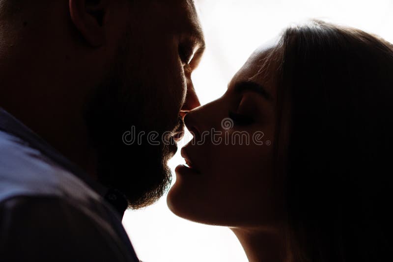 Ritratto di una coppia romantica in una lampadina da una finestra o da una porta, siluetta di una coppia in una entrata con una l fotografia stock Ritratto di una coppia romantica in una lampadina da una finestra o da una porta, siluetta di una coppia in una entrata con una l fotografia stock