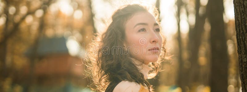 Ritratto di una donna che cammina nel parco autunnale felice umore e moda stile moda e capelli marroni ricci e lunghi fotografia stock libera da diritti
