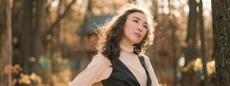 Ritratto di una donna che cammina nel parco autunnale felice umore e moda stile moda e capelli marroni ricci e lunghi fotografia stock libera da diritti