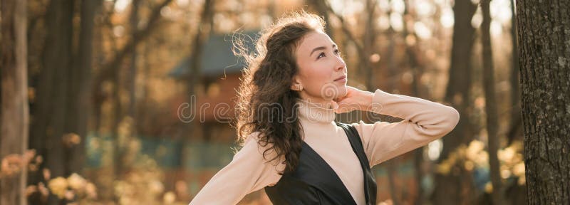 Ritratto di una donna che cammina nel parco autunnale felice umore e moda stile moda e capelli marroni ricci e lunghi immagini stock