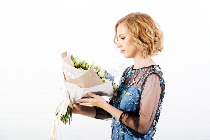 Ritratto di una donna con un mazzo dei fiori in sue mani immagine stock Ritratto di una donna con un mazzo dei fiori in sue mani immagine stock