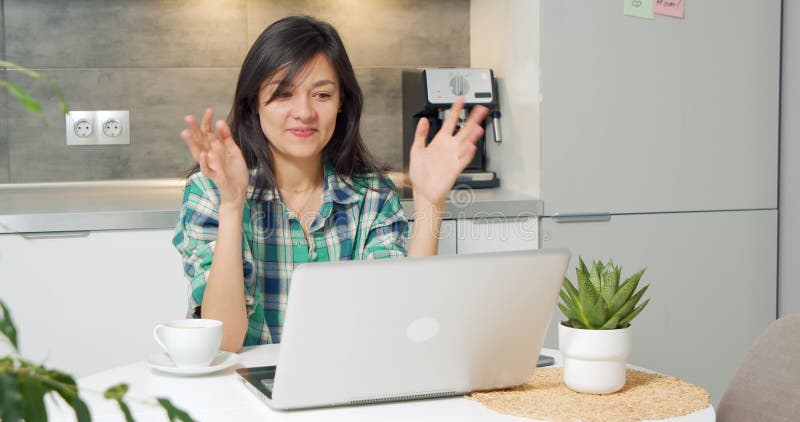 Ritratto di una donna sorridente che fa una videochiamata online sul portatile della cucina. donna felice che chiacchiera con un a