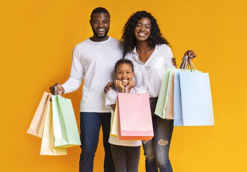 Ritratto di una famiglia afro-americana felice che tiene borse della spesa