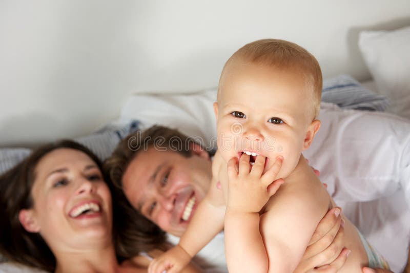 Ritratto di una famiglia felice che ride con il bambino immagine stock Ritratto di una famiglia felice che ride con il bambino immagine stock