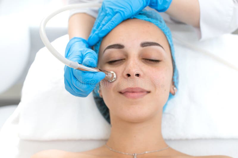 Ritratto di una giovane bellissima ragazza sottoposta a una terapia a vuoto Assistenza e ringiovanimento sul volto Aumento del to fotografie stock libere da diritti Ritratto di una giovane bellissima ragazza sottoposta a una terapia a vuoto Assistenza e ringiovanimento sul volto Aumento del to fotografie stock libere da diritti