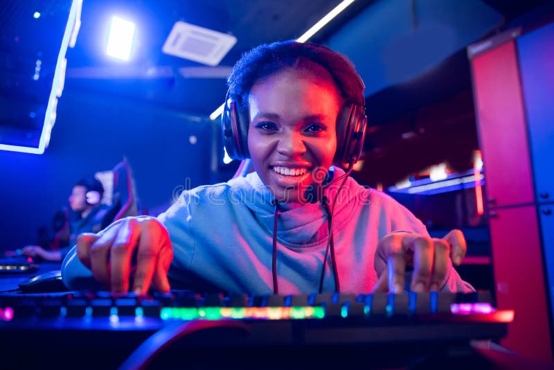 Ritratto di una giovane donna africana giocatore professionista che gioca online con un computer neon color fotografia stock libera da diritti