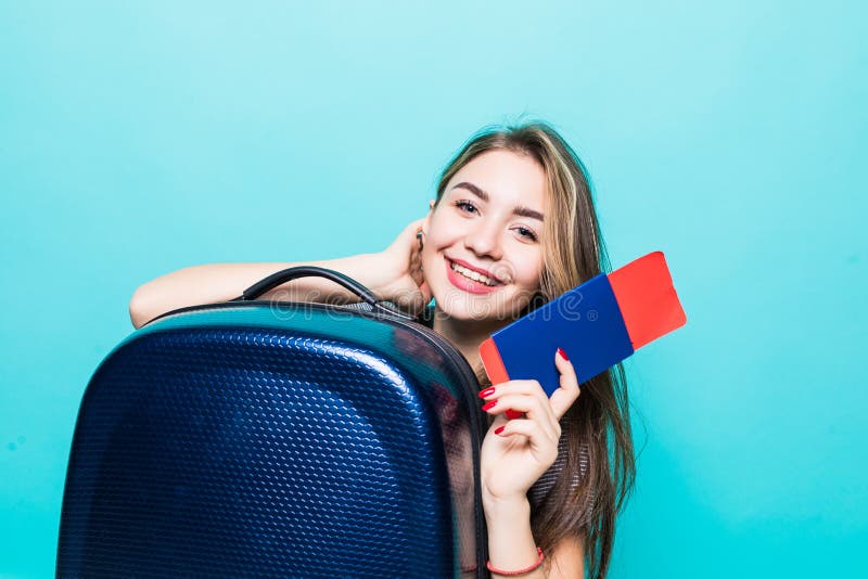 Ritratto di una giovane donna allegra vestita in vestiti di estate che tengono passaporto con i biglietti di volo mentre stando c fotografia stock libera da diritti Ritratto di una giovane donna allegra vestita in vestiti di estate che tengono passaporto con i biglietti di volo mentre stando c fotografia stock libera da diritti
