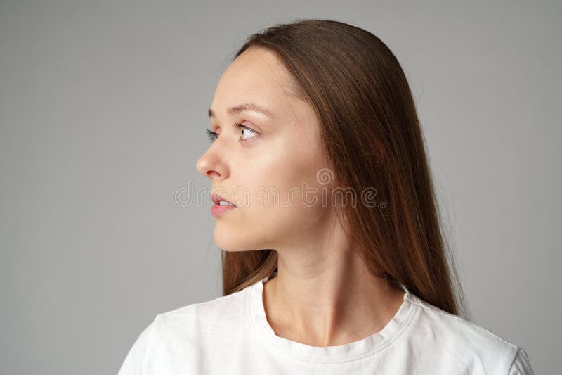 Ritratto di una giovane donna in camicia bianca sullo sfondo grigio fotografia stock