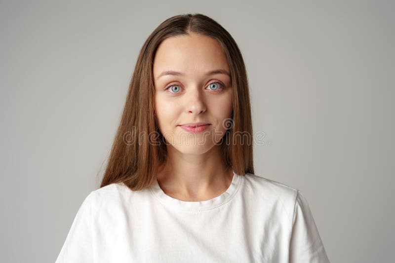 Ritratto di una giovane donna in camicia bianca sullo sfondo grigio fotografie stock libere da diritti