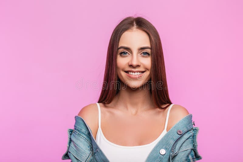 Ritratto di una giovane donna di colore blu alla moda, con un sorriso incantevole, con una giacca di denim blu in una maglietta bi fotografia stock