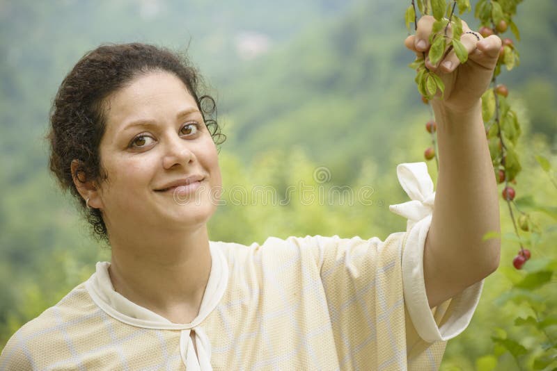 Ritratto di una giovane donna felice che tiene un concetto di ramo-agricoltura del susino fotografia stock Ritratto di una giovane donna felice che tiene un concetto di ramo-agricoltura del susino fotografia stock