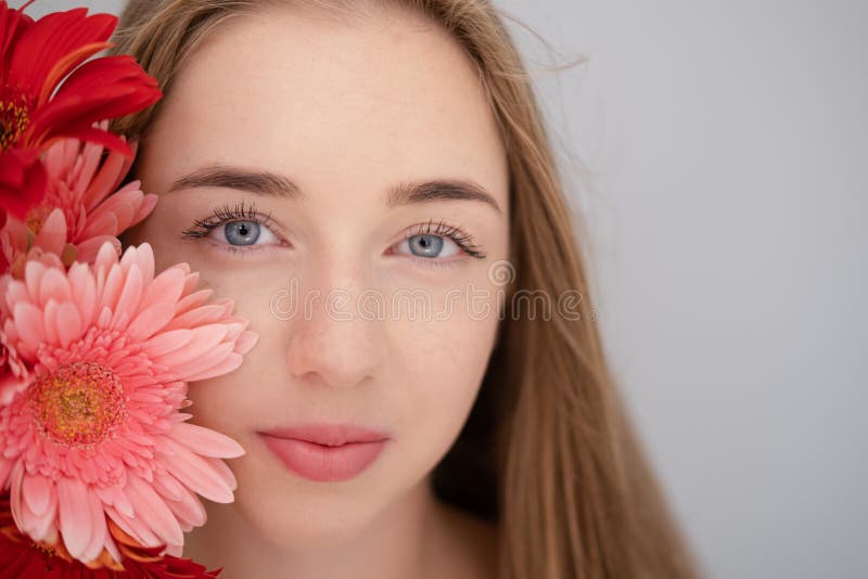 Ritratto di una giovane donna graziosa con fiori di crisantemo rosa e rosso fotografia stock
