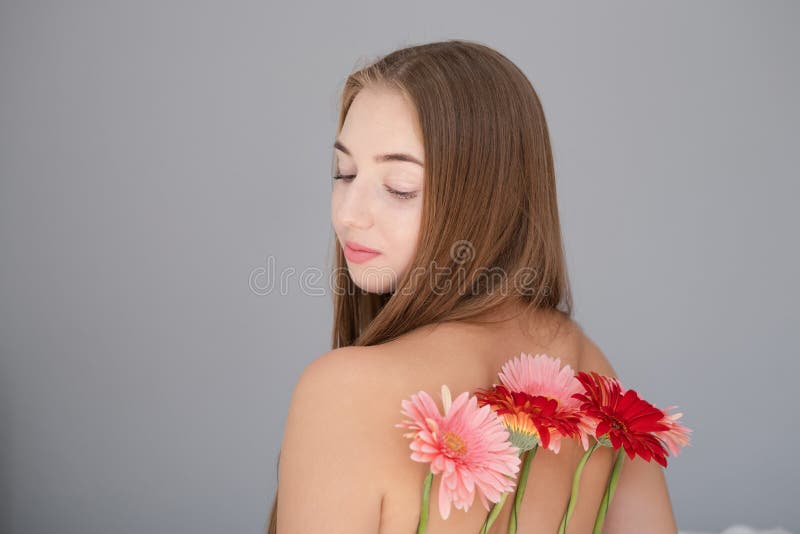 Ritratto di una giovane donna graziosa con fiori di crisantemo rosa e rosso immagine stock